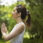 年轻的亚洲妇女在花园练瑜伽健康生活方式和放松