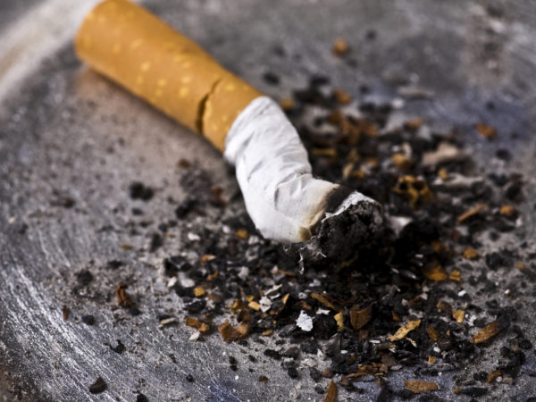白色烟托盘和滤波灭入银色烟灰缸烟尾全有灰色 焦点在烟尾