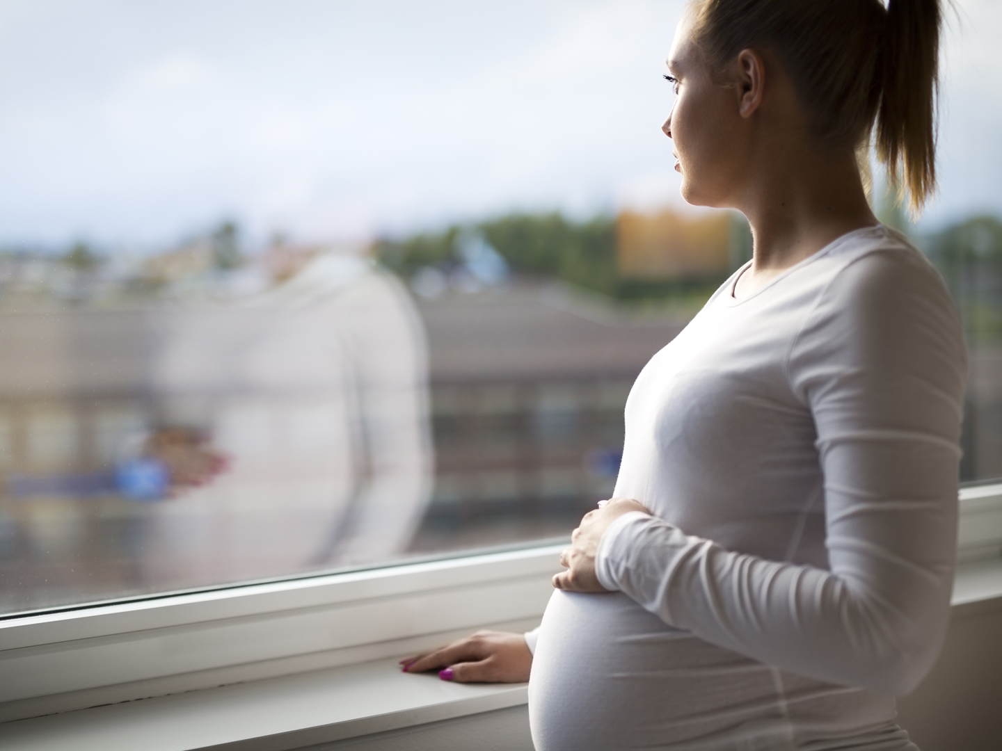 深思熟虑的孕妇望窗外家手抓肚子心理健康和怀孕